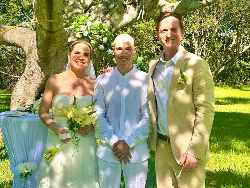 Newlyweds and their officiant under a banyan tree at a Miami garden wedding